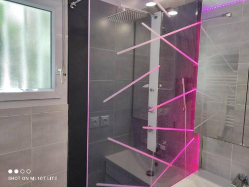 La salle de bains est pourvue d'une douche et d'étagères roses. dans l'établissement Villa 1, Natura Beach au village naturiste, au Cap d'Agde