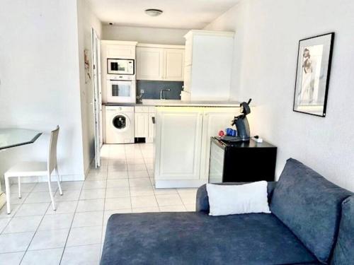 un salon avec un canapé et une cuisine dans l'établissement Villa 1, Natura Beach au village naturiste, au Cap d'Agde