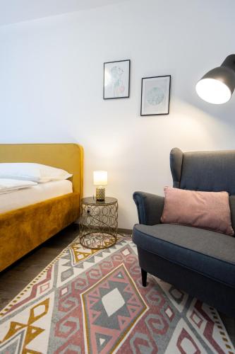 Moravská OstravaにあるNova Karolina Apartmentのベッドとソファと椅子のある寝室