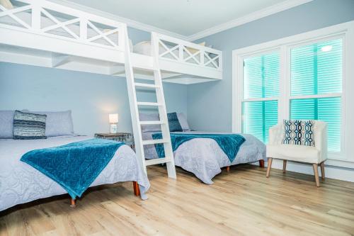 a bedroom with two beds and a ladder at Cottage Beach House Steps From Beach 3 bedroom 2 bath in Gulf Shores