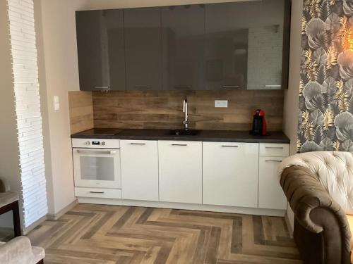 a kitchen with white cabinets and a sink at Nowy apartament prime video in Opole