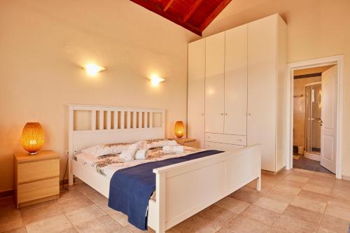 a bedroom with a large white bed and two lamps at Edem Paradise in Plimmiri