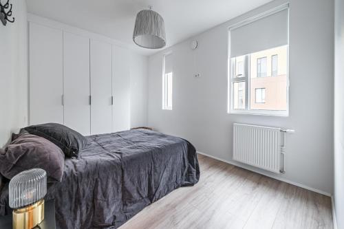 - une chambre blanche avec un lit et une fenêtre dans l'établissement Glacial Properties, Cozy apartment in Kópavogur, à Reykjavik