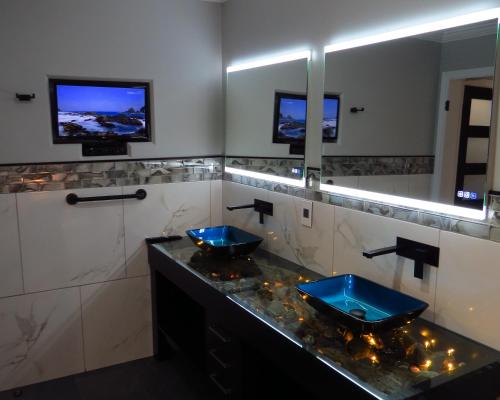 a bathroom with two blue sinks and two mirrors at Dockside Suites in Digby