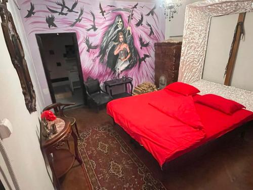 Un dormitorio con una cama roja con una pintura en la pared en Vlads Place 