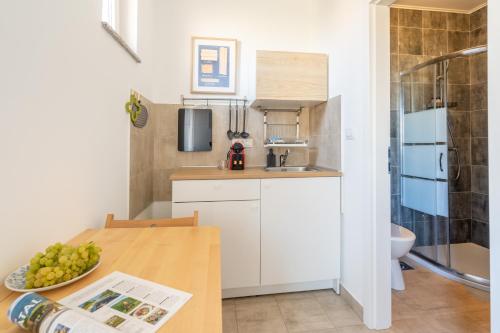 uma pequena cozinha com uma mesa e um lavatório em Sunny & Cosy Studio wParking em Rovinj