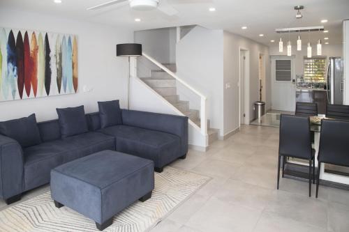 a living room with a blue couch and a staircase at 246C, South Finger, Waterfront in Jolly Harbour