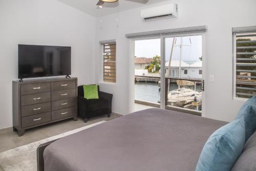 a bedroom with a bed and a television and a window at 246C, South Finger, Waterfront in Jolly Harbour