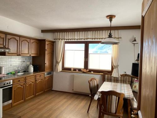 uma cozinha com mesa e cadeiras e uma janela em Haus Reichlas em Längenfeld
