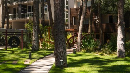 a sidewalk in front of a building with trees at Mizu Hotel Boutique in Mar de las Pampas