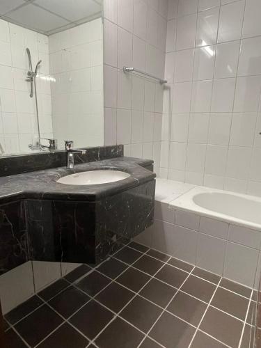 a bathroom with a sink and a tub and a mirror at Studio close to Burj Khalifa and Downtown Dubai in Dubai