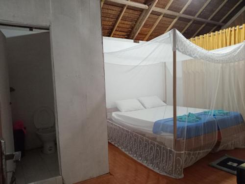 a bed with a canopy in a room at Lalosi Homestay in Besir