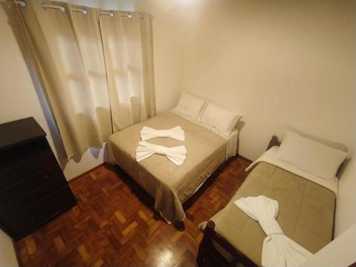 a small room with two beds and a television at Cantinho do sossego in Campos do Jordão