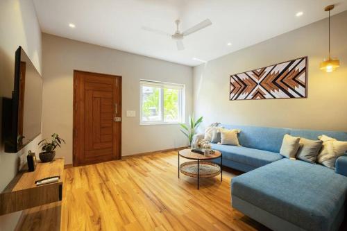 sala de estar con sofá azul y mesa en Blissful Grand 3BHK Villa Getaway Row Villa 2 en Camorlim