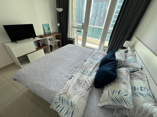 a bedroom with a bed and a tv and a window at 1 bedroom Apartment with Dubai Marina & Seaview in Dubai
