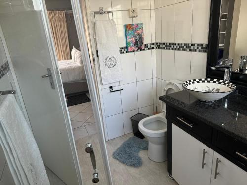 a bathroom with a toilet and a sink and a shower at 389b Beautiful Bachelor Cottage in Johannesburg