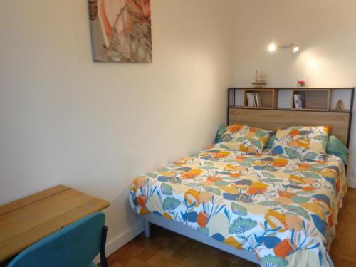 a small bedroom with a bed and a wooden table at Le Relais Médiéval in Fougères
