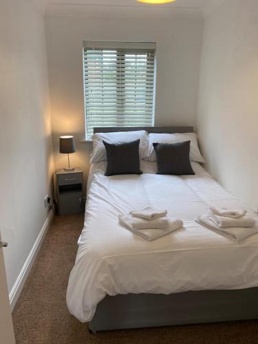 a bedroom with a large white bed with towels on it at Luxury 2 Bedroom Aparmant in Morley in Morley