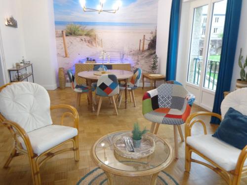 a dining room with chairs and a table with a beach mural at Le Relais Médiéval in Fougères