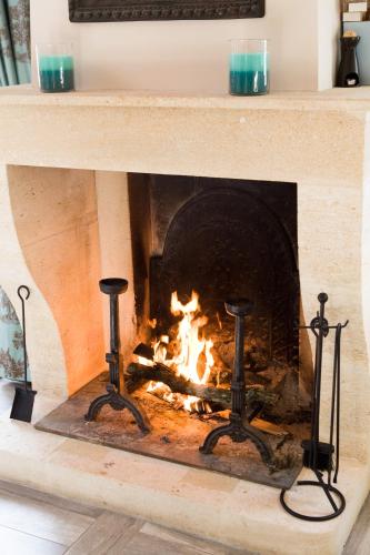 a fireplace with two candles in front of it at Château Latour Segur Suites & Spa in Lussac