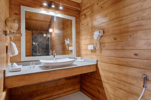 uma casa de banho com um lavatório e um espelho em Stone Wood Jungle Resort, Dandeli em Dandeli