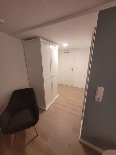 a room with a black chair and a closet at Zimmer im Souterrain mit eigenem Bad in Celle