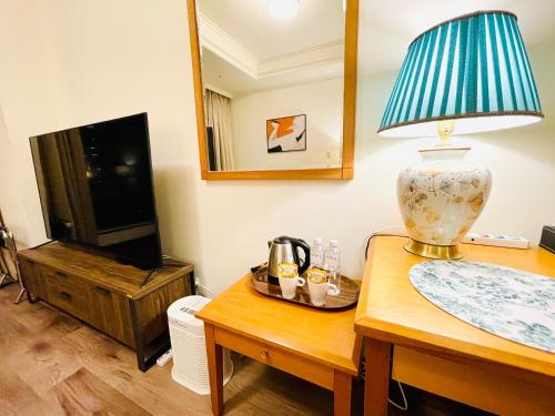 a living room with a table with a lamp and a mirror at 台中自由行 in Taichung