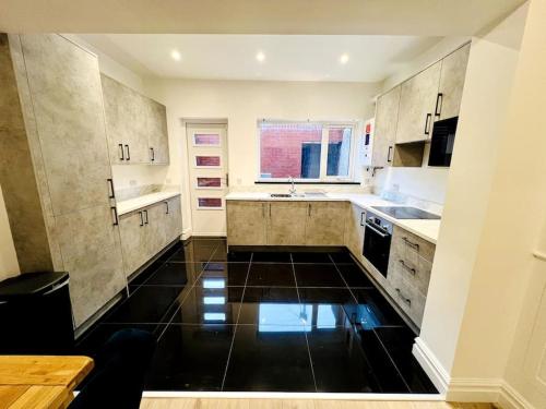 a kitchen with a black floor and white cabinets at Modern 2-bed in Blyth centre in Blythe