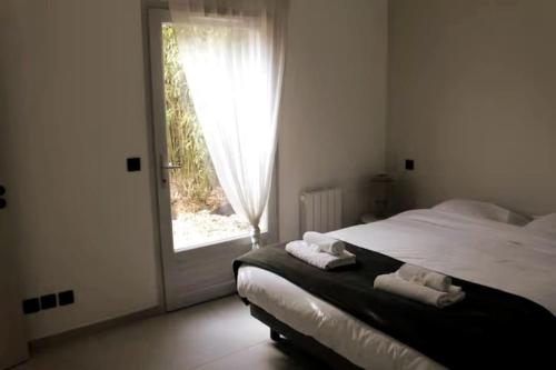 Schlafzimmer mit einem Bett und einem Fenster mit Handtüchern in der Unterkunft Superbe Appartement avec Clim/Terrasse/Parking in Montpellier