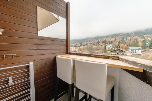 a balcony with two chairs and a table and a window at Chamonix Sud - Grepon 408 - Happy Rentals in Chamonix-Mont-Blanc