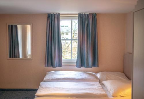a bedroom with a bed and a window with curtains at Stäffele City Appartements in Stuttgart