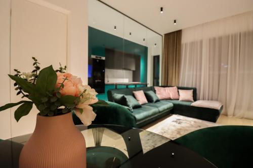 布加勒斯特的住宿－Como Business Inn，客厅配有沙发和鲜花花瓶