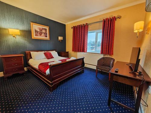 羅瑟勒姆的住宿－Carlton Park Hotel Rotherham，配有一张床和一张书桌的酒店客房