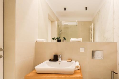 布加勒斯特的住宿－Como Business Inn，浴室设有白色水槽和镜子