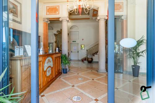 an open door to a room with a lobby with columns at HOTIDAY Hotel Verbania in Verbania