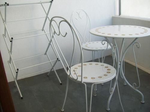 duas cadeiras brancas e uma mesa e uma prateleira em Jardin del Mar em Coquimbo