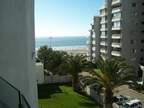 uma vista para a praia a partir da varanda de um edifício em Jardin del Mar em Coquimbo