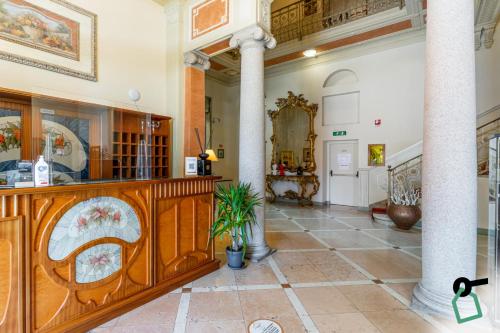 a large room with a pillar and a lobby at HOTIDAY Hotel Verbania in Verbania