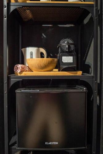 a black shelf with a bowl and a coffee maker at Suite 180° - Lago di Como in Blevio