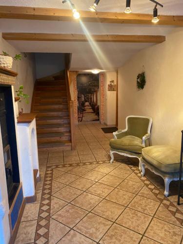 a hallway with two chairs and a stairway with stairs at Annahof in Argenbühl
