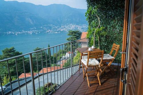 a table and chairs on a balcony with a view at Suite 180° - Lago di Como in Blevio