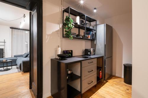 - une cuisine avec un comptoir et un réfrigérateur dans la chambre dans l'établissement bevoflats - Stilvolles Souterrain am Mehringdamm, à Berlin