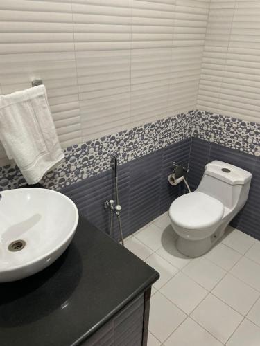 a bathroom with a white toilet and a sink at Hotel Crescent in Tahkāl Pāyān