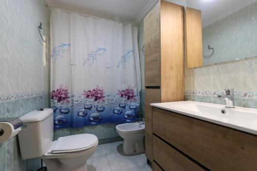 a bathroom with a toilet and a sink and a shower curtain at 042 - Las Marismas I - 002 comfortHOLIDAYS in Santa Pola