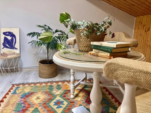 una mesa con libros y plantas encima de una alfombra en Atico de madera Apartamento en Rinlo, RIBADEO, en Ribadeo