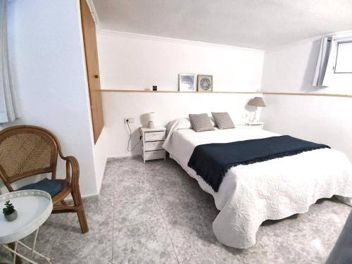 um quarto com uma cama, uma mesa e uma cadeira em Apartamento Munay en Playa Albir em Foyes Blanques