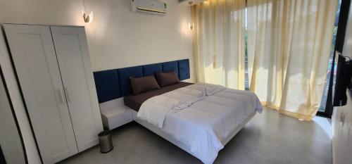 a bedroom with a large bed with a blue headboard at Riverside Farm in Murud