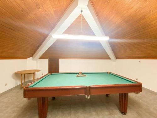 una mesa de billar en una habitación con techo en GH Odivelas - Quartos em Casa com Bilhar! 