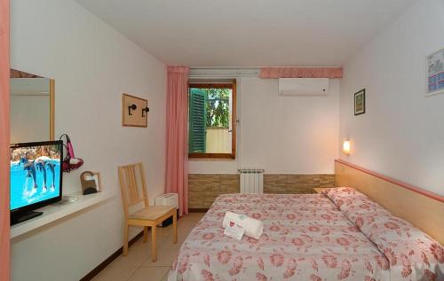 a bedroom with a bed and a flat screen tv at Storyville Simple Stay in Cinquale