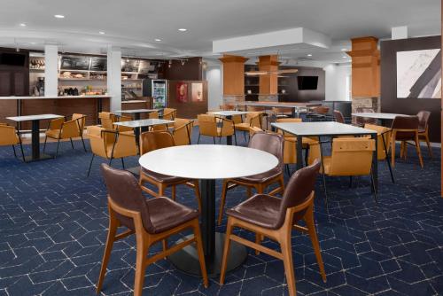 uma sala de jantar com mesas e cadeiras em Courtyard by Marriott Phoenix West/Avondale em Phoenix